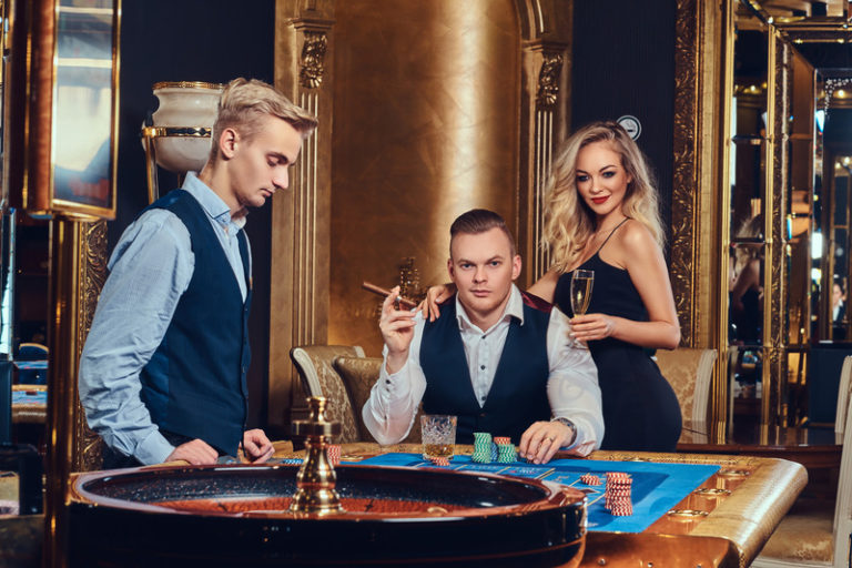 Players and a dealer at a roulette table